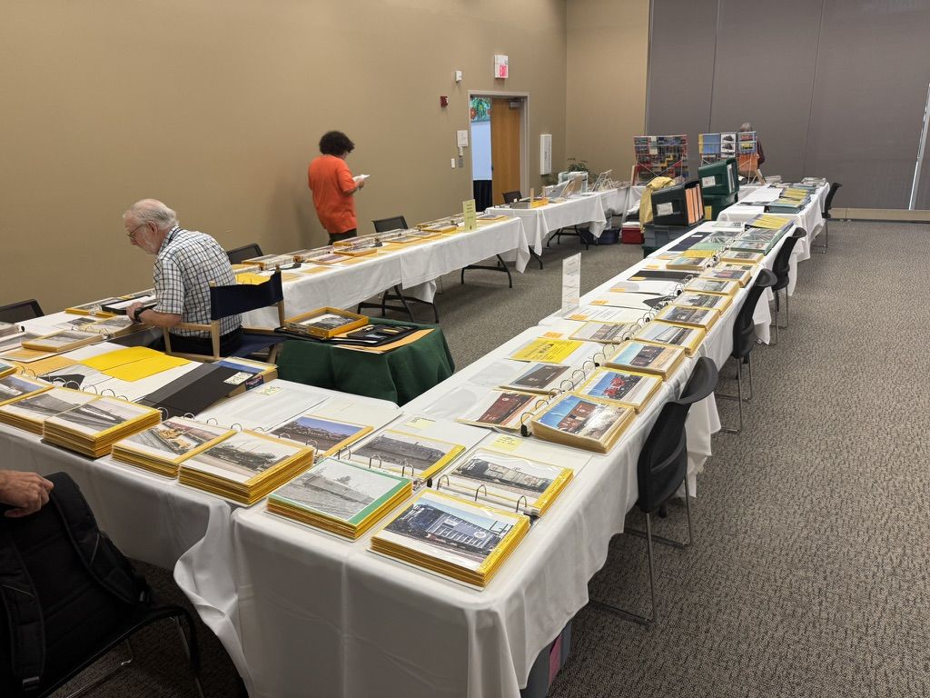 Long tables of photo binders with attendees browsing